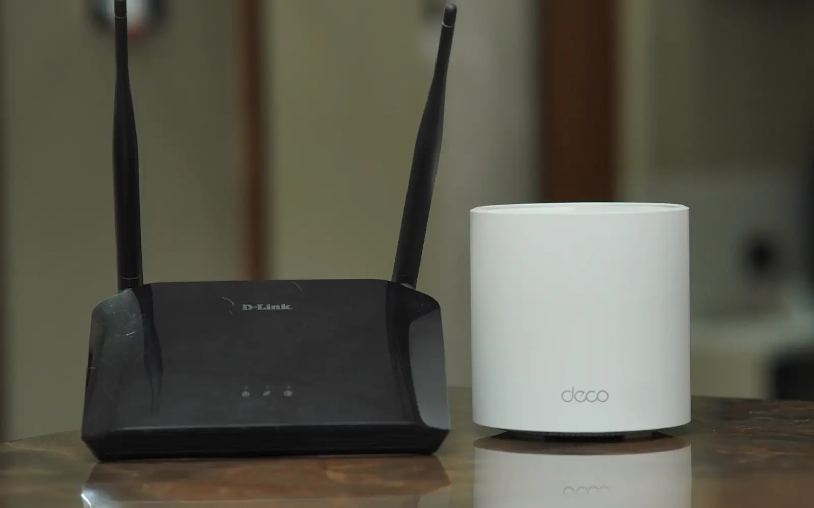 Συμβατικό Wi-Fi router δίπλα σε συσκευή mesh